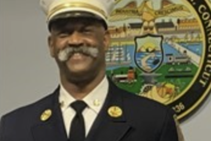 Fire chief standing in front of Bridgeport city seal