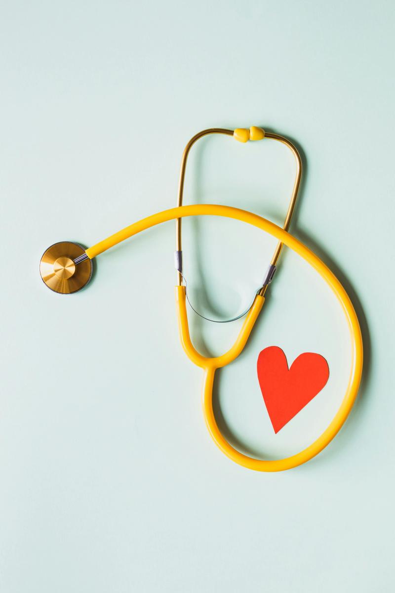 A yellow stethoscope and a red paper heart
