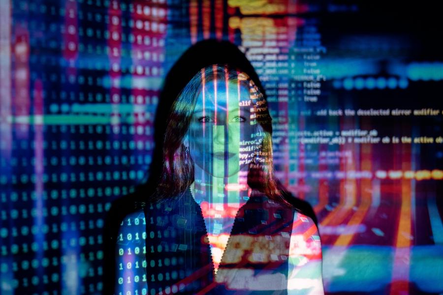 Woman with colorful computer code projected over her face